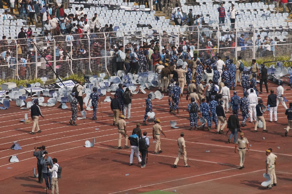 Security forces managing crowd disorder in Kolkata stadium during Messi India tour showing the contrast of Kolkata Chaos vs Hyderabad Harmony.