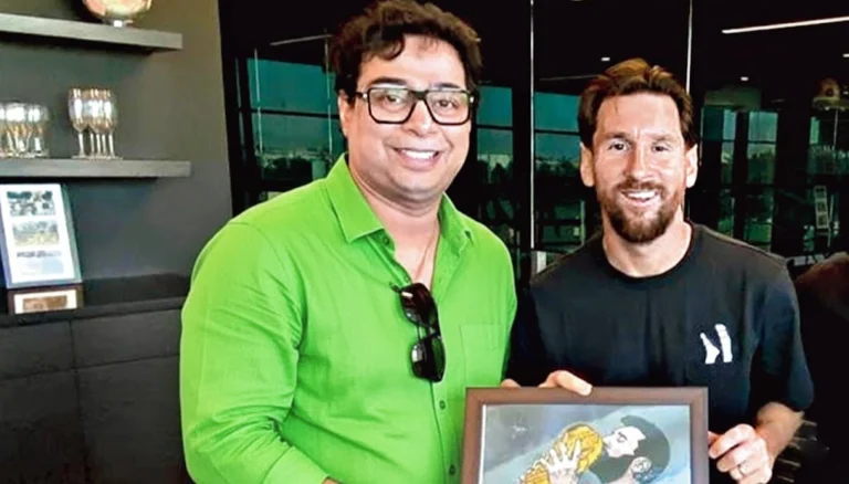 Satadru Dutta with Lionel Messi during Messi GOAT India Tour 2025 holding framed artwork of Messi with World Cup trophy.