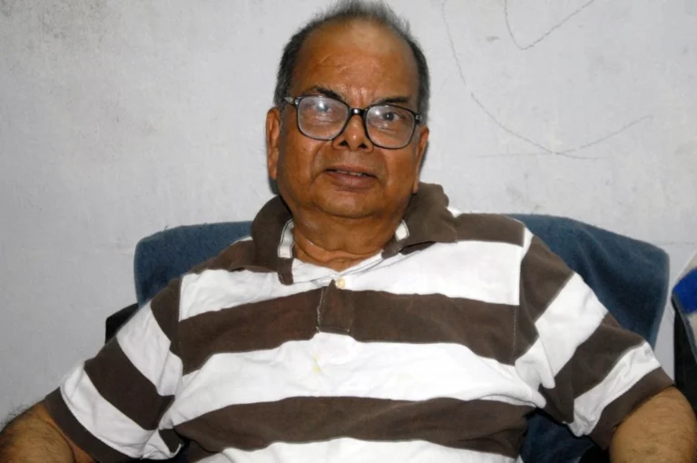 Sankar Bengali novelist Mani Shankar Mukherjee writing at desk in Kolkata
