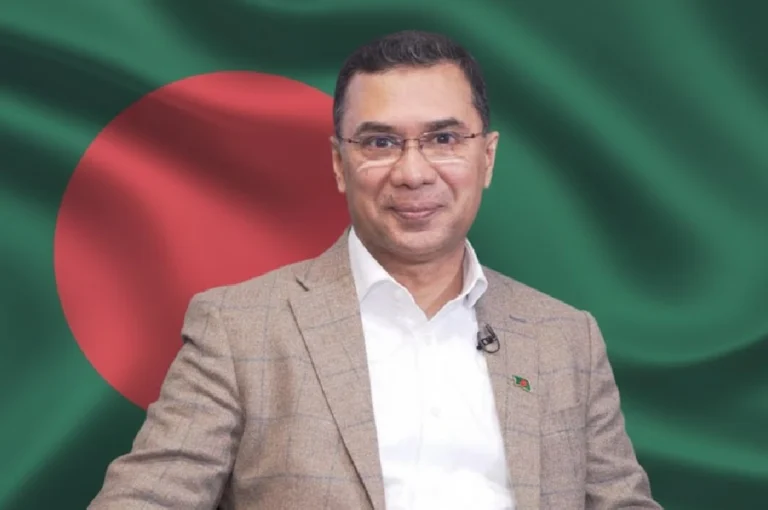 তারেক রহমান: নির্বাসন পেরিয়ে ক্ষমতার দোরগোড়ায়—বাংলাদেশ কি দেখছে নতুন অধ্যায়ের সূচনা? Tarique Rahman portrait with Bangladesh flag background, smiling and wearing a beige blazer.
