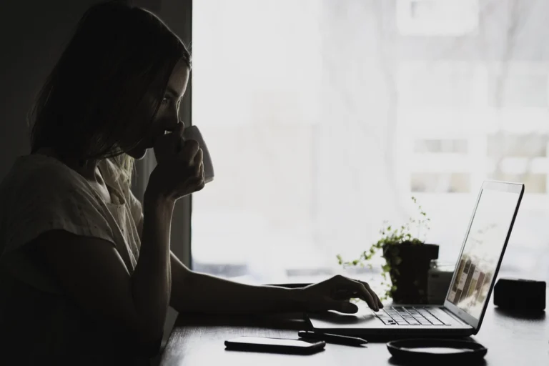 A yellow MacBook Neo on a student's desk with an iPhone, representing the Apple ecosystem and affordability for college students.